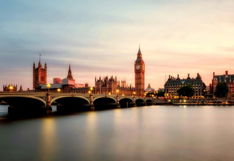 Scenic view of Big Ben and Westminster Bridge over the Thames River at sunset in London, UK.