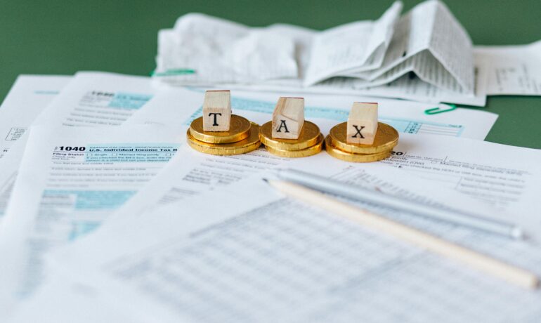 Close-up of tax forms, receipts, and coins symbolizing financial accounting and taxes.
