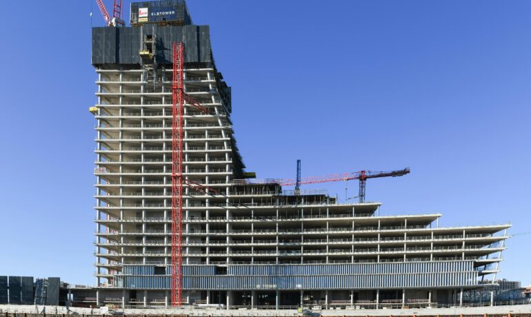 Aerial view of a modern high-rise under construction in Hamburg, featuring cranes and concrete structures.